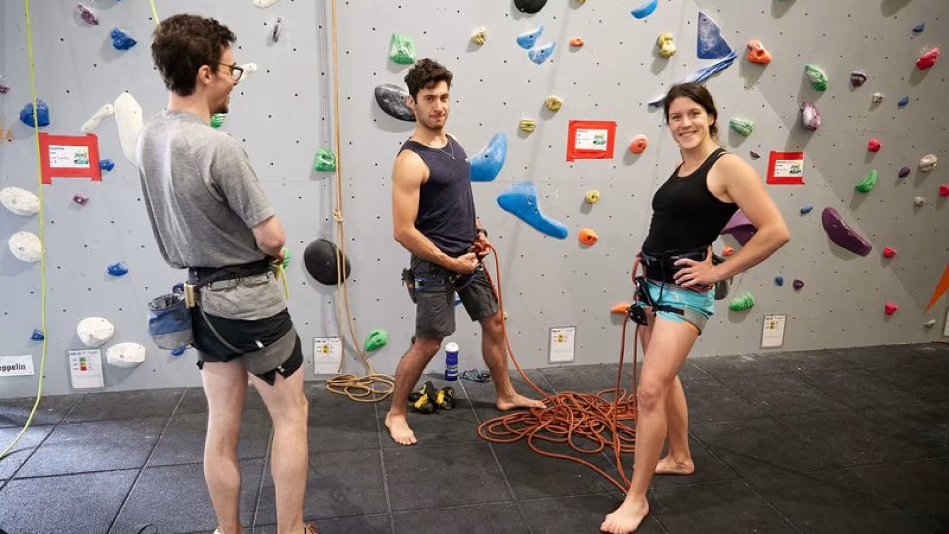 2 men and 1 woman climbers preparing ropes to climb